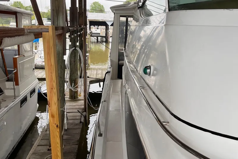 Slide: The Image of 2002 Carver 466 Motor Yacht docked at marina, side view with wooden pier. - 6