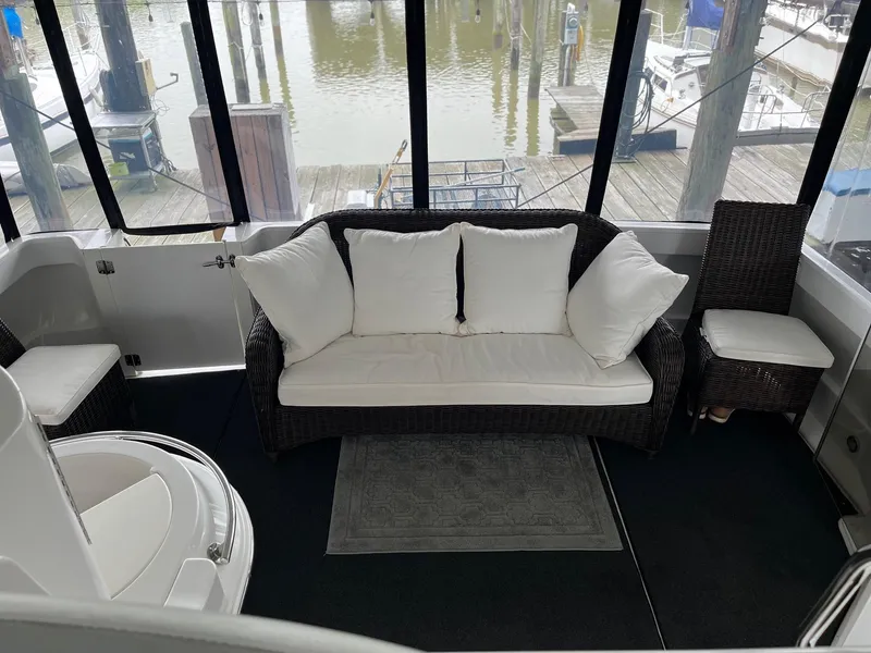 Slide: The Image of Interior of 2002 Carver 466 Motor Yacht with wicker seating and marina view. - 10