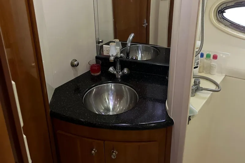 Slide: The Image of 2002 Carver 466 Motor Yacht bathroom with sink, mirror, and toiletries. - 24