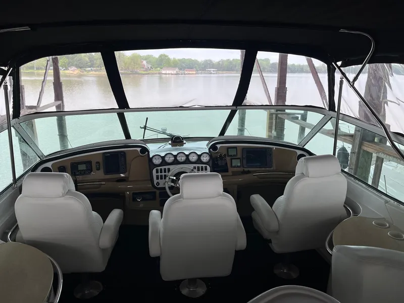 Slide: The Image of 2002 Carver 466 Motor Yacht helm with white seats and panoramic water view. - 30