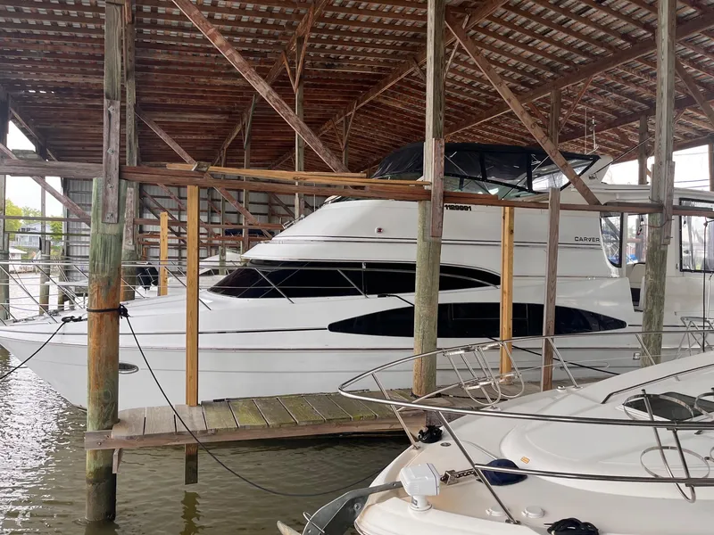 Slide: The Image of 2002 Carver 466 Motor Yacht docked under a wooden shelter. - 4