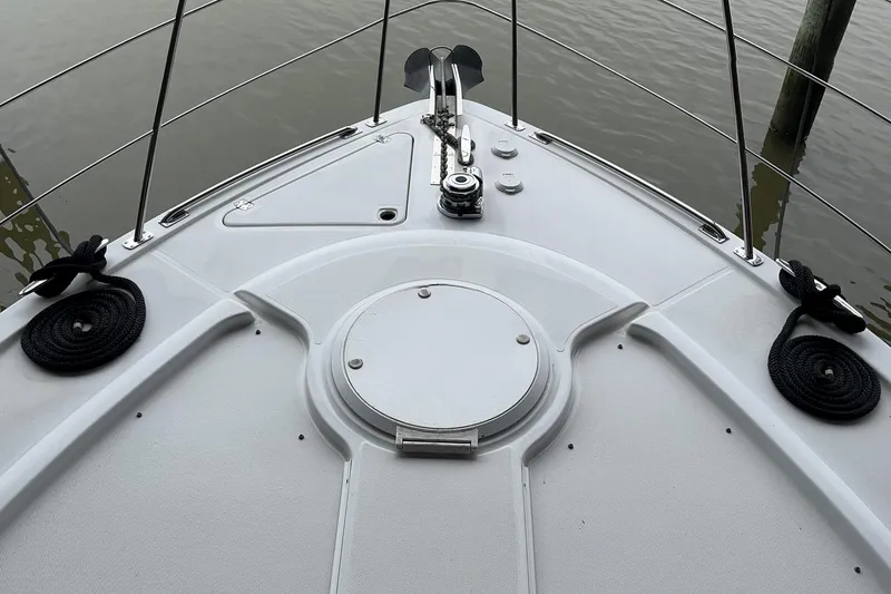 Slide: The Image of Bow of 2002 Carver 466 Motor Yacht with anchor and railing, docked on calm water. - 8