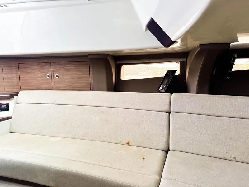 Slide: The Image of Interior of 2017 Boston Whaler 420 Outrage with beige seating and wooden cabinets. - 23