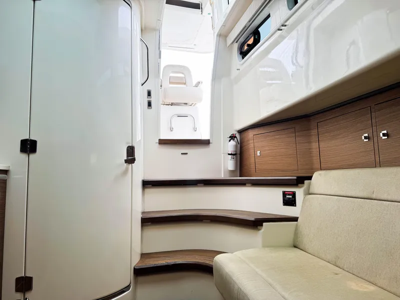 Slide: The Image of 2017 Boston Whaler 420 Outrage interior with stairs, seating, and wooden cabinetry. - 28