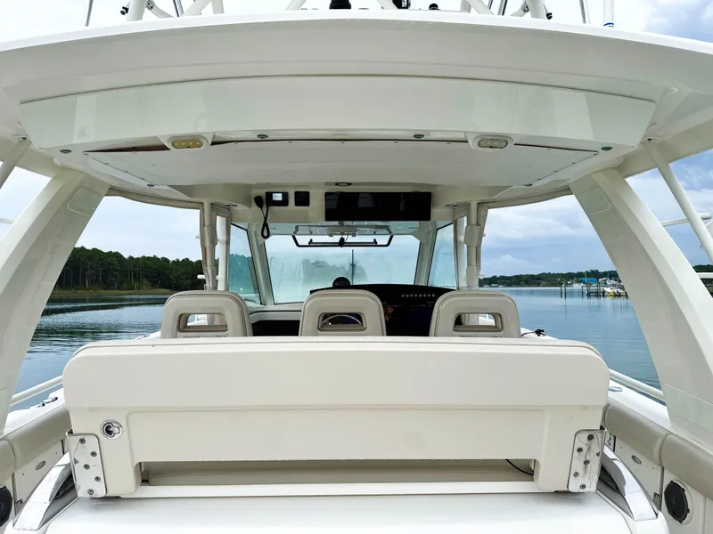 Slide: The Image of 2017 Boston Whaler 420 Outrage boat interior with seating and helm, on calm water. - 31
