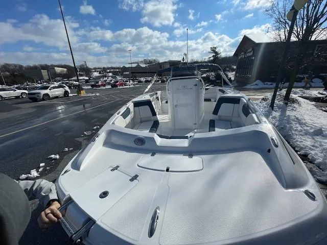 Slide: The Image of 2024 Tahoe 2150 CC boat in a snowy parking lot under a blue sky. - 2