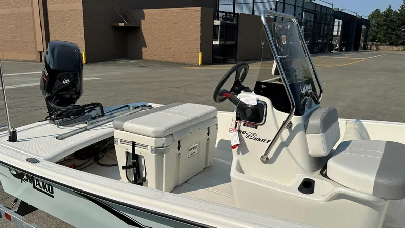 Slide: The Image of 2024 Mako Pro Skiff 15 CC boat with console and cooler on deck. - 2