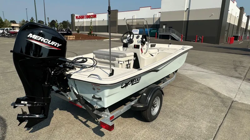 Slide: The Image of 2024 Mako Pro Skiff 15 CC boat with Mercury engine on trailer in parking lot. - 3