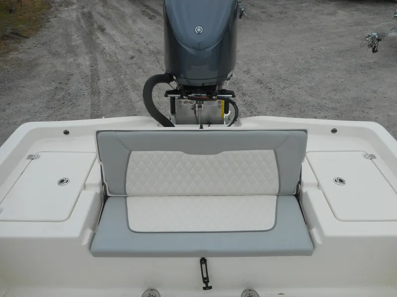 Slide: The Image of 2024 Avenger 26 Avenger boat with cushioned seating and outboard motor. - 8