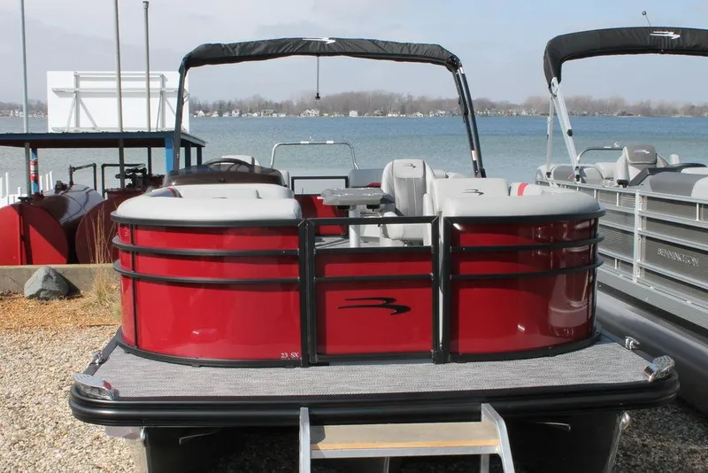 Slide: The Image of 2024 Bennington 23 SXSR pontoon boat docked by the lake. - 11
