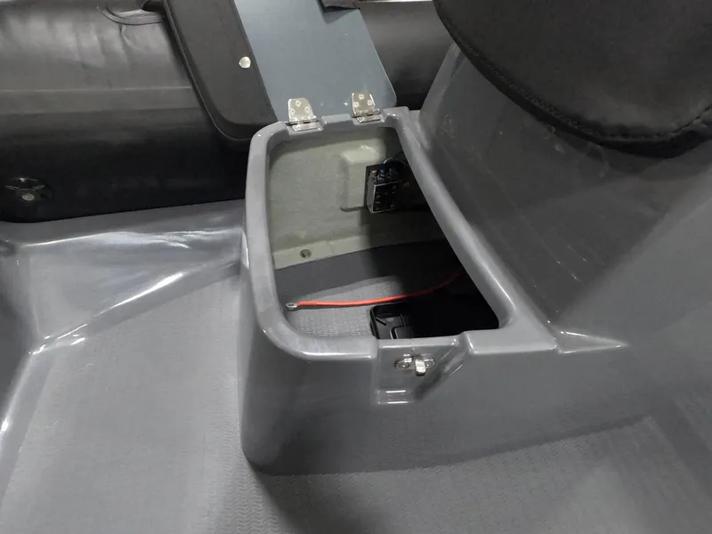 Slide: The Image of 2024 Grand Inflatables S370NL storage compartment with open lid and visible wiring. - 12