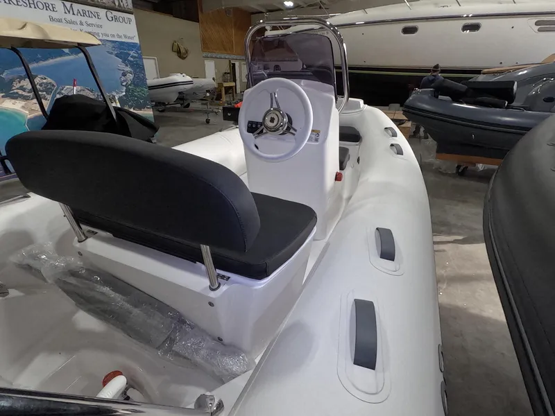 Slide: The Image of 2024 Grand Inflatables S370NL boat interior with steering console and seating. - 13