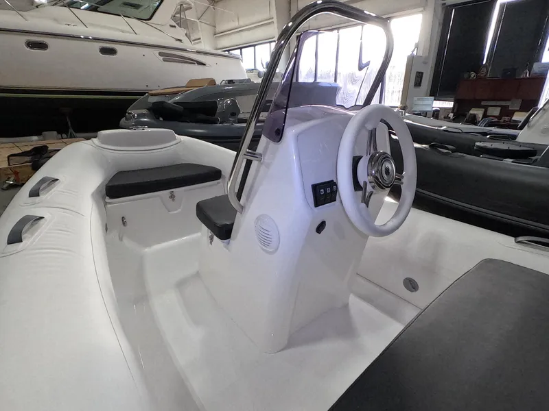 Slide: The Image of 2024 Grand Inflatables S370NL boat interior with steering console and seating. - 10
