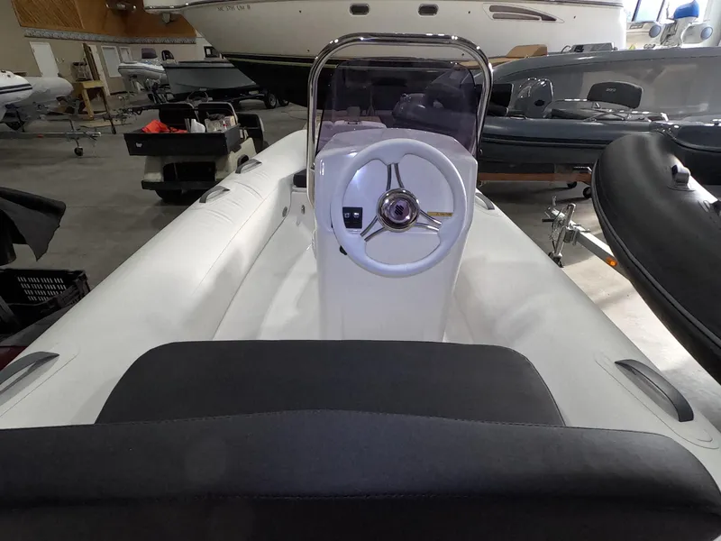 Slide: The Image of 2024 Grand Inflatables S370NL boat interior with steering wheel and seating. - 12