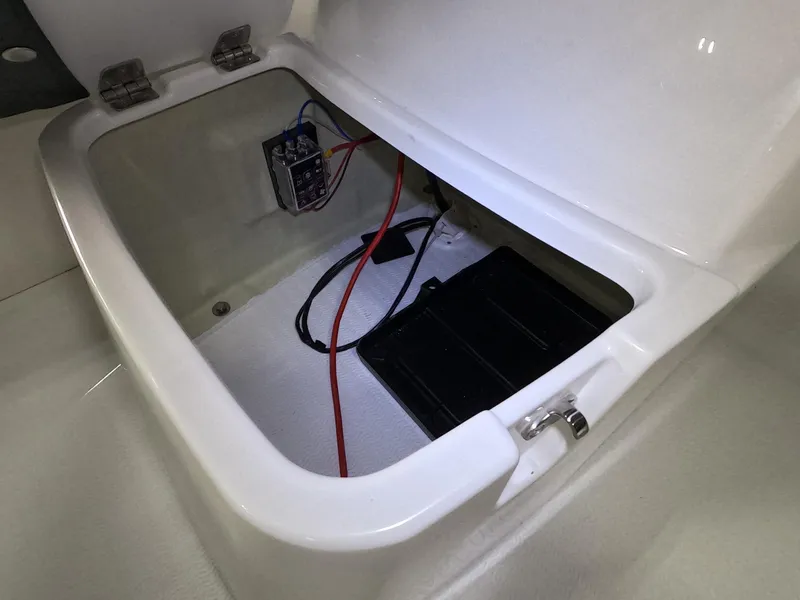 Slide: The Image of Open storage compartment of 2024 Grand Inflatables S370NL boat with wiring and battery. - 7