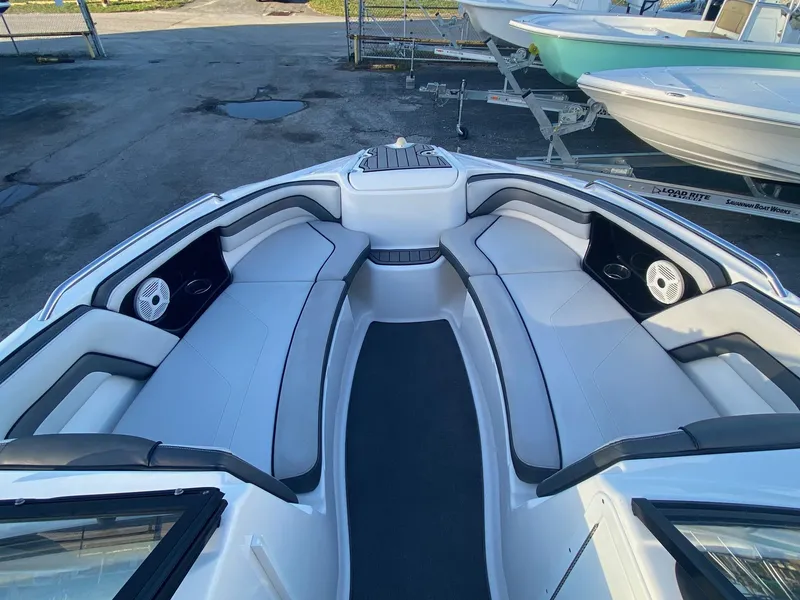 Slide: The Image of 2018 Yamaha Boats AR240 HO interior seating area with white and black upholstery. - 16