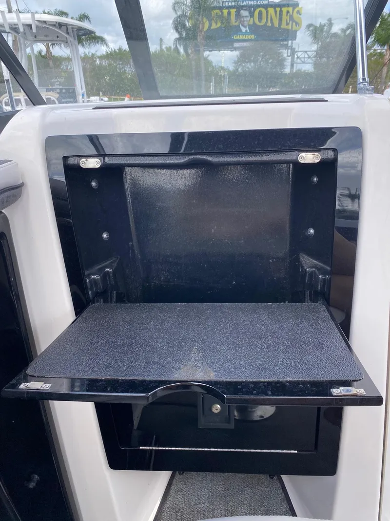 Slide: The Image of 2018 Yamaha Boats AR240 HO storage compartment with fold-out tray. - 27