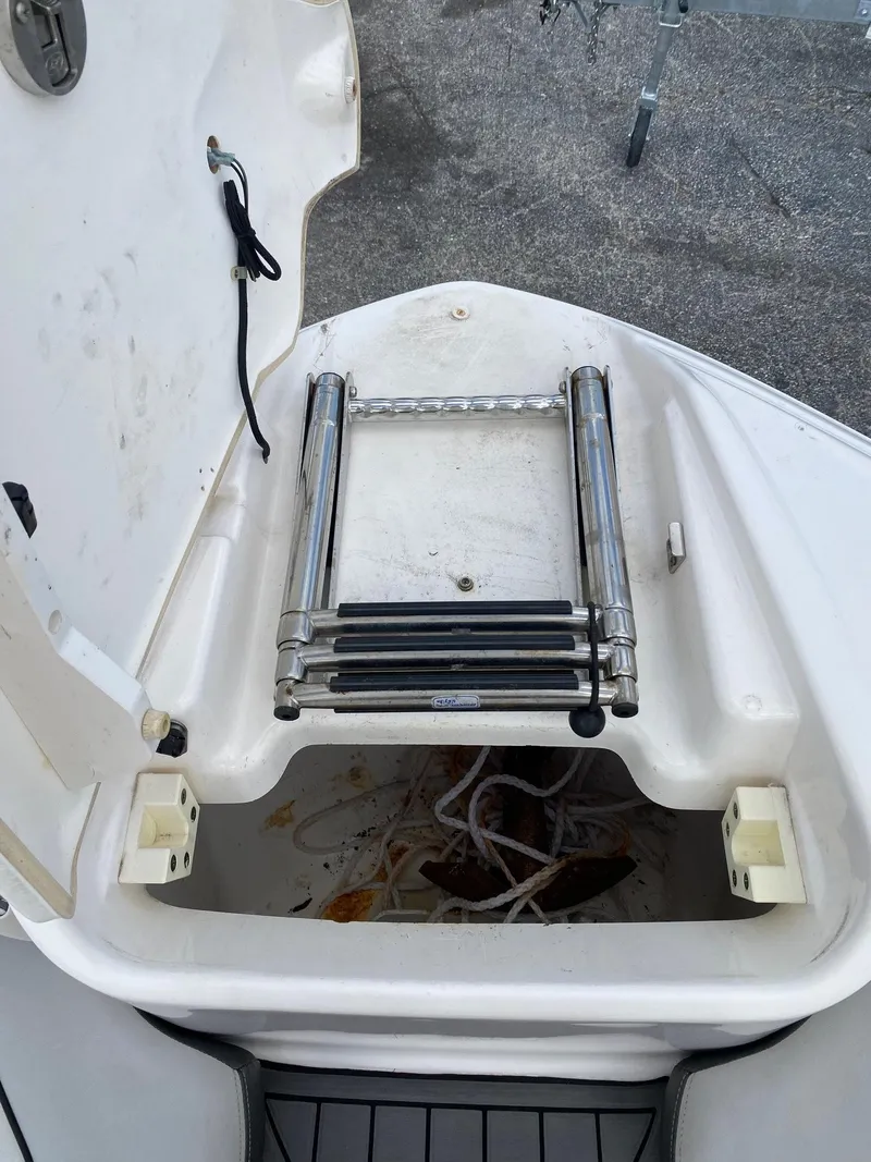 Slide: The Image of 2018 Yamaha Boats AR240 HO bow storage compartment with foldable ladder. - 28