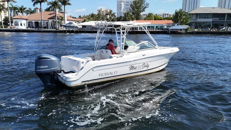 Slide: The Image of 2015 Robalo R247 Dual Console boat cruising on a sunny waterway. - 2