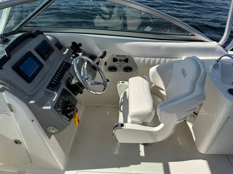 Slide: The Image of 2015 Robalo R247 Dual Console boat interior with steering wheel and captain's chair. - 22