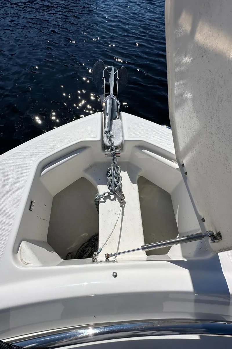 Slide: The Image of 2015 Robalo R247 Dual Console boat anchor compartment with chain, on calm water. - 32