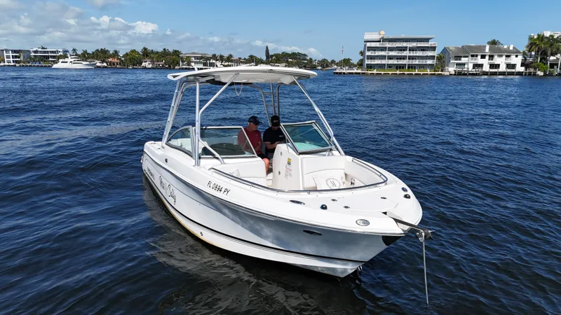 Slide: The Image of 2015 Robalo R247 Dual Console boat on calm water, sunny day, coastal background. - 9