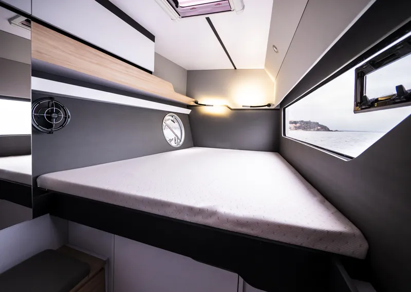 Slide: The Image of Modern cabin interior of the 2025 Windelo 50 Adventure yacht with a cozy bed and porthole. - 37