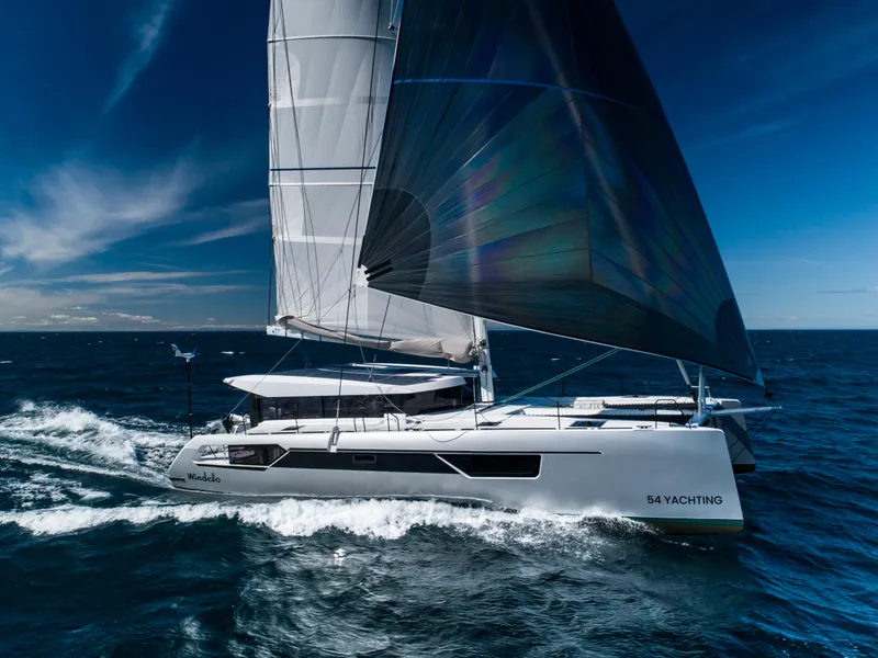 Slide: The Image of Windelo 54 sailing yacht 2025 gliding on open ocean under clear blue sky. - 23