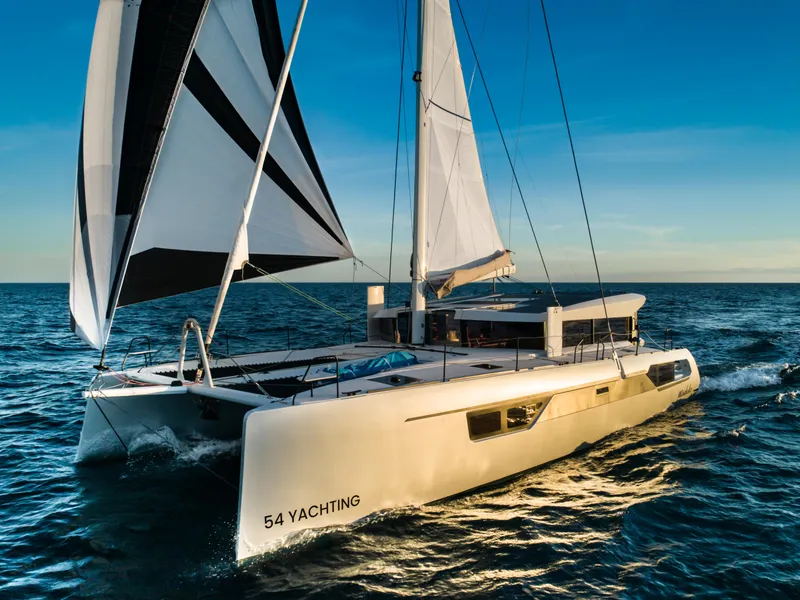 Slide: The Image of Windelo 54 catamaran sailing on open sea at sunset, 2025 model. - 25