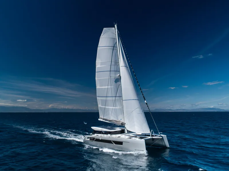 Slide: The Image of Windelo 54 sailing catamaran 2025 gliding on open ocean under clear blue sky. - 2