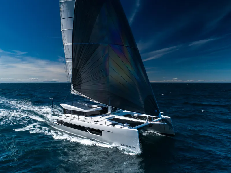 Slide: The Image of 2025 Windelo 54 catamaran sailing on open ocean under clear blue sky. - 20