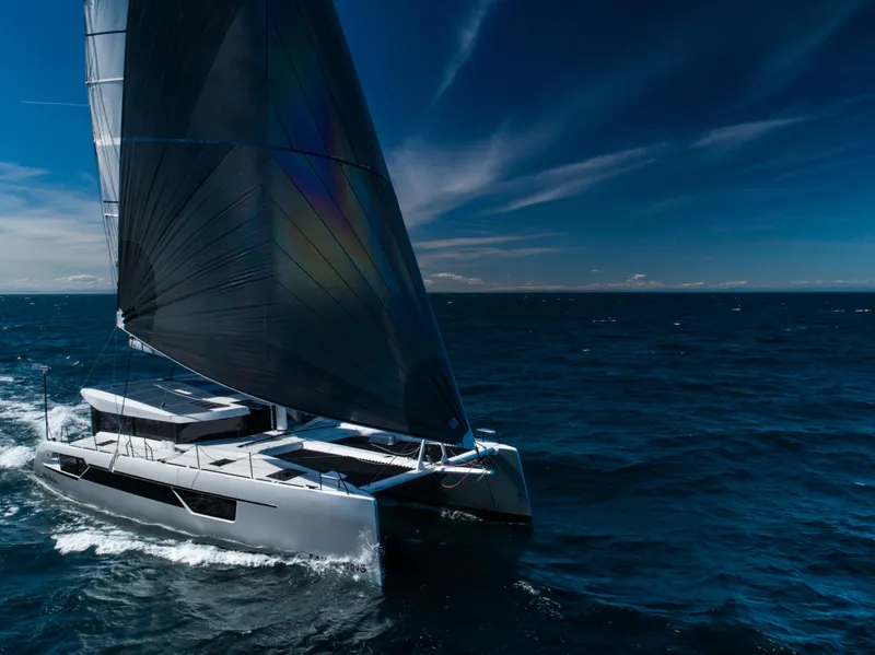 Slide: The Image of 2025 Windelo 54 sailing catamaran on open ocean under clear blue sky. - 22