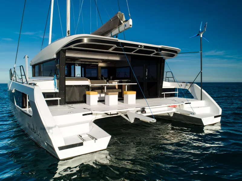 Slide: The Image of 2025 Windelo 54 catamaran on calm ocean waters, showcasing open deck and modern design. - 30