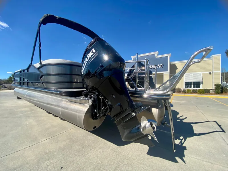 Slide: The Image of 2023 Vanderbilt 700T pontoon boat with Suzuki outboard motor. - 2