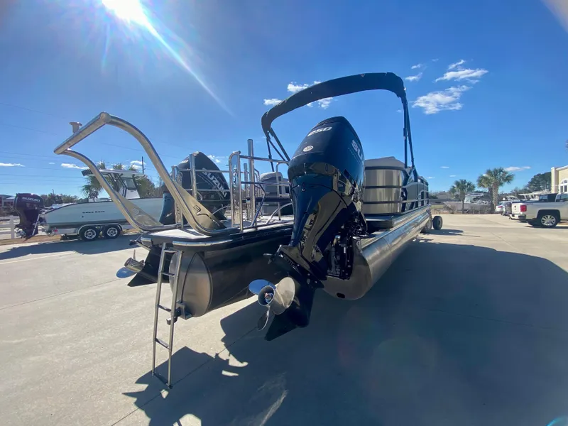 Slide: The Image of 2023 Vanderbilt 700T pontoon boat with outboard motor in a sunny marina. - 5