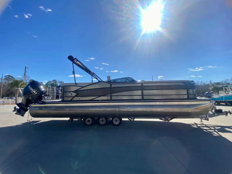 Slide: The Image of 2023 Vanderbilt 700T pontoon boat on trailer under bright sun. - 6
