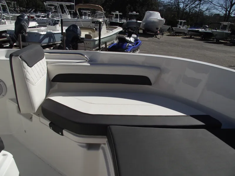 Slide: The Image of 2024 Bayliner CC20 boat interior seating area with white and black cushions. - 31