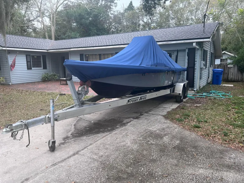 Slide: The Image of 2020 Blazer 2200 Fisherman boat on trailer with blue cover in driveway. - 10