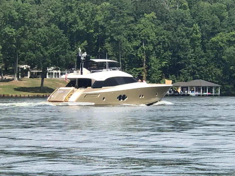 Slide: The Image of 2012 Monte Carlo Yachts 76 cruising on a serene lake with lush green trees. - 1