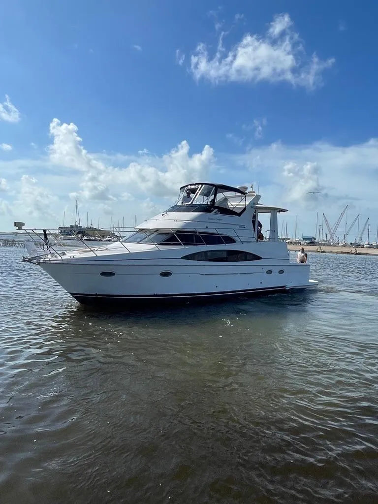 Slide: The Image of 2001 Carver 444 Cockpit Motor Yacht on calm water under blue sky. - 2
