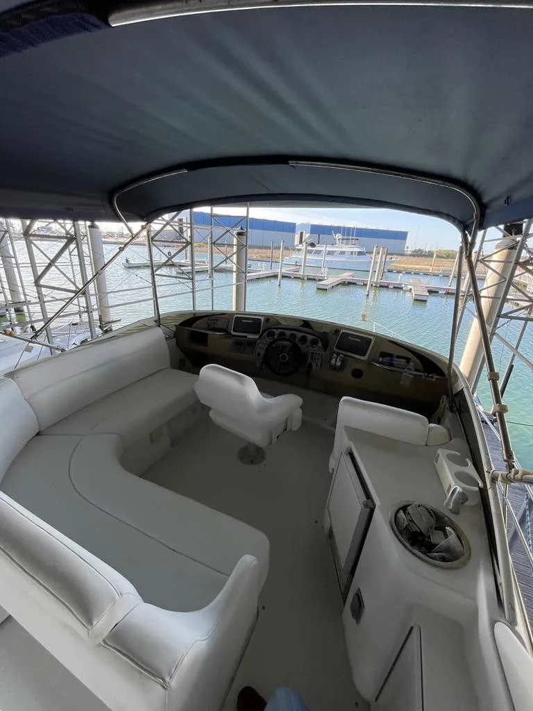 Slide: The Image of 2001 Carver 444 Cockpit Motor Yacht interior with helm, seating, and marina view. - 27