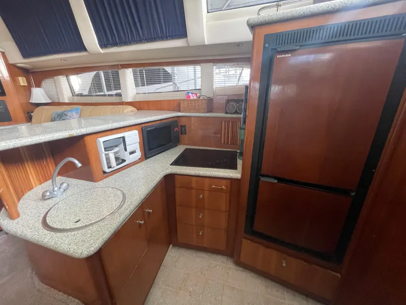 Slide: The Image of Interior of 2001 Carver 444 Cockpit Motor Yacht kitchen with appliances and wood cabinetry. - 46