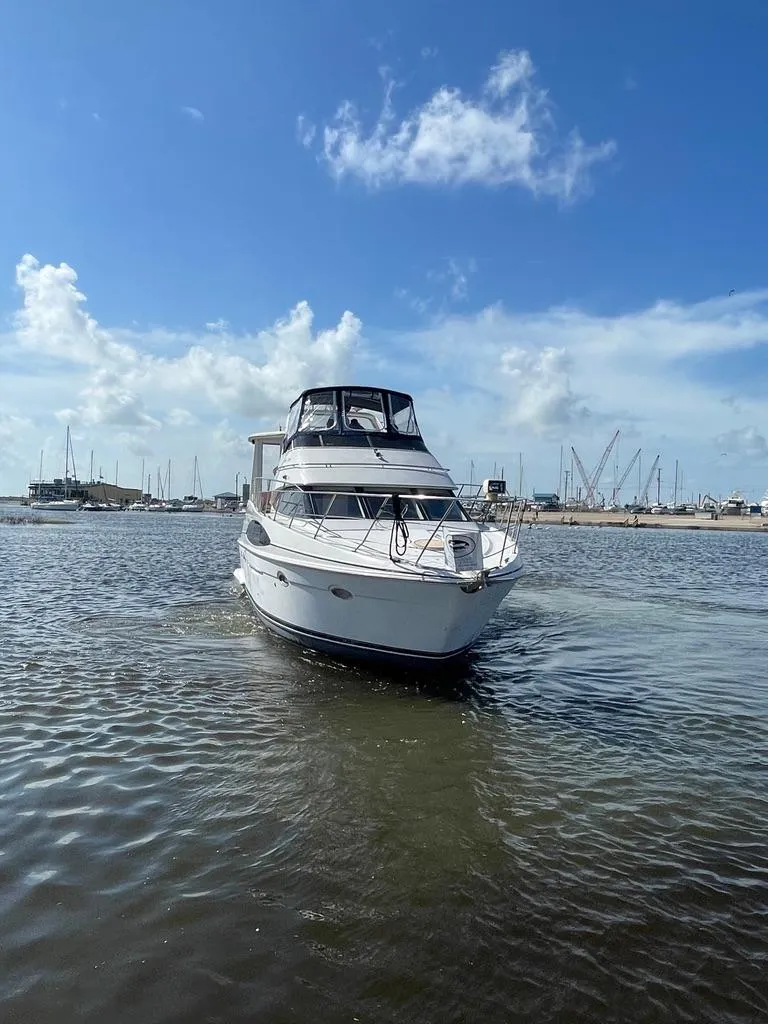 Slide: The Image of 2001 Carver 444 Cockpit Motor Yacht on calm water, sunny day, marina background. - 6