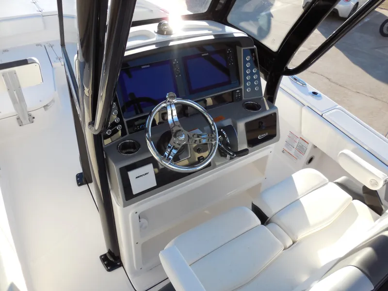 Slide: The Image of 2024 Robalo R266 Cayman boat helm with dual displays and steering wheel. - 6