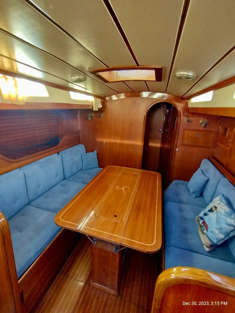 Slide: The Image of Interior of 1974 Nautor Swan 38 sailboat with wooden table and blue seating. - 10