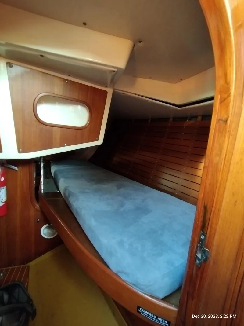 Slide: The Image of 1974 Nautor Swan 38 cabin interior with wooden finish and blue mattress. - 12