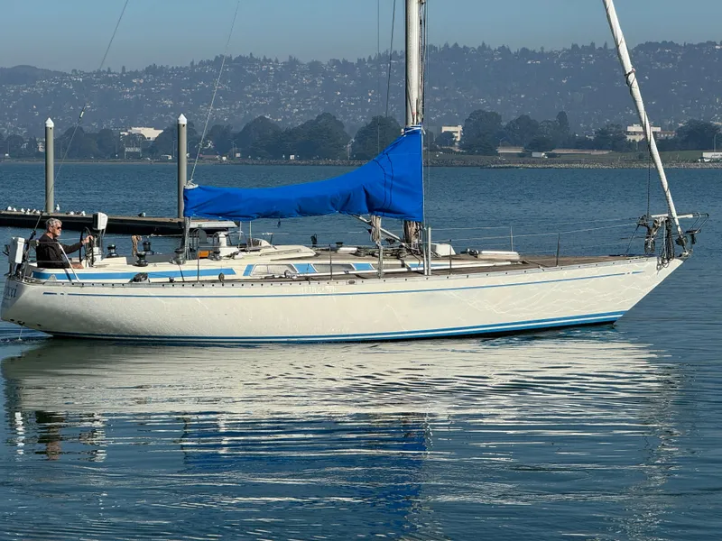 Slide: The Image of 1974 Nautor Swan 38 sailboat with blue sail cover on calm water. - 16