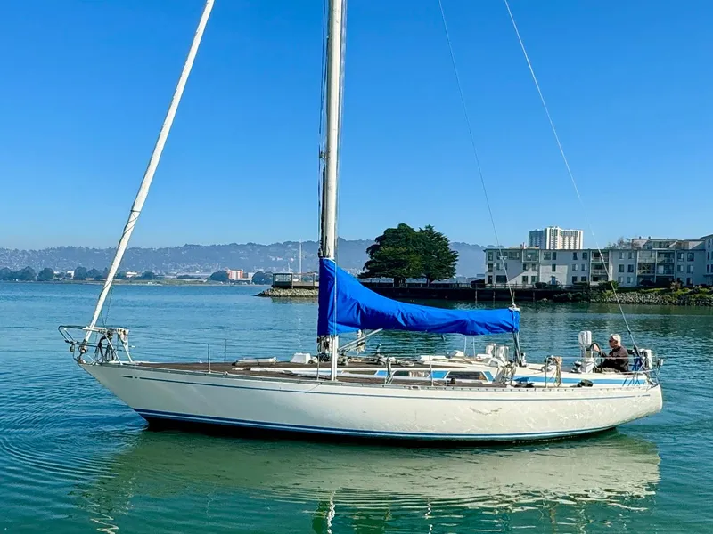 Slide: The Image of 1974 Nautor Swan 38 sailboat with blue sail cover on calm water. - 3