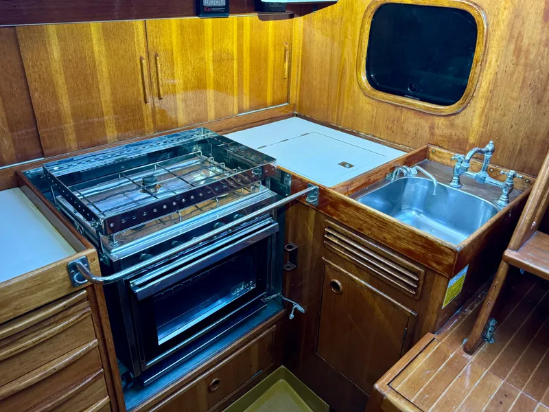 Slide: The Image of Vintage 1974 Nautor Swan 38 yacht kitchen with wood cabinetry, stove, and sink. - 7