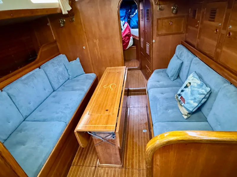 Slide: The Image of Interior of 1974 Nautor Swan 38 yacht with blue seating and wooden table. - 8
